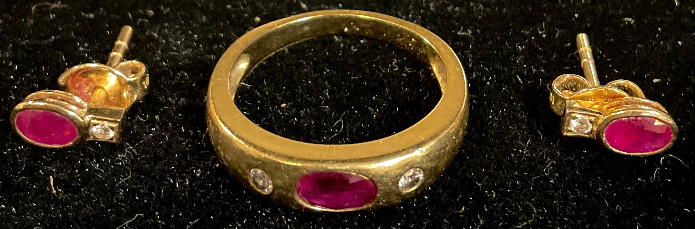 An 18k gold ruby and diamond three stone ring, size N/O, apparently unmarked, 4.3g, with certificate