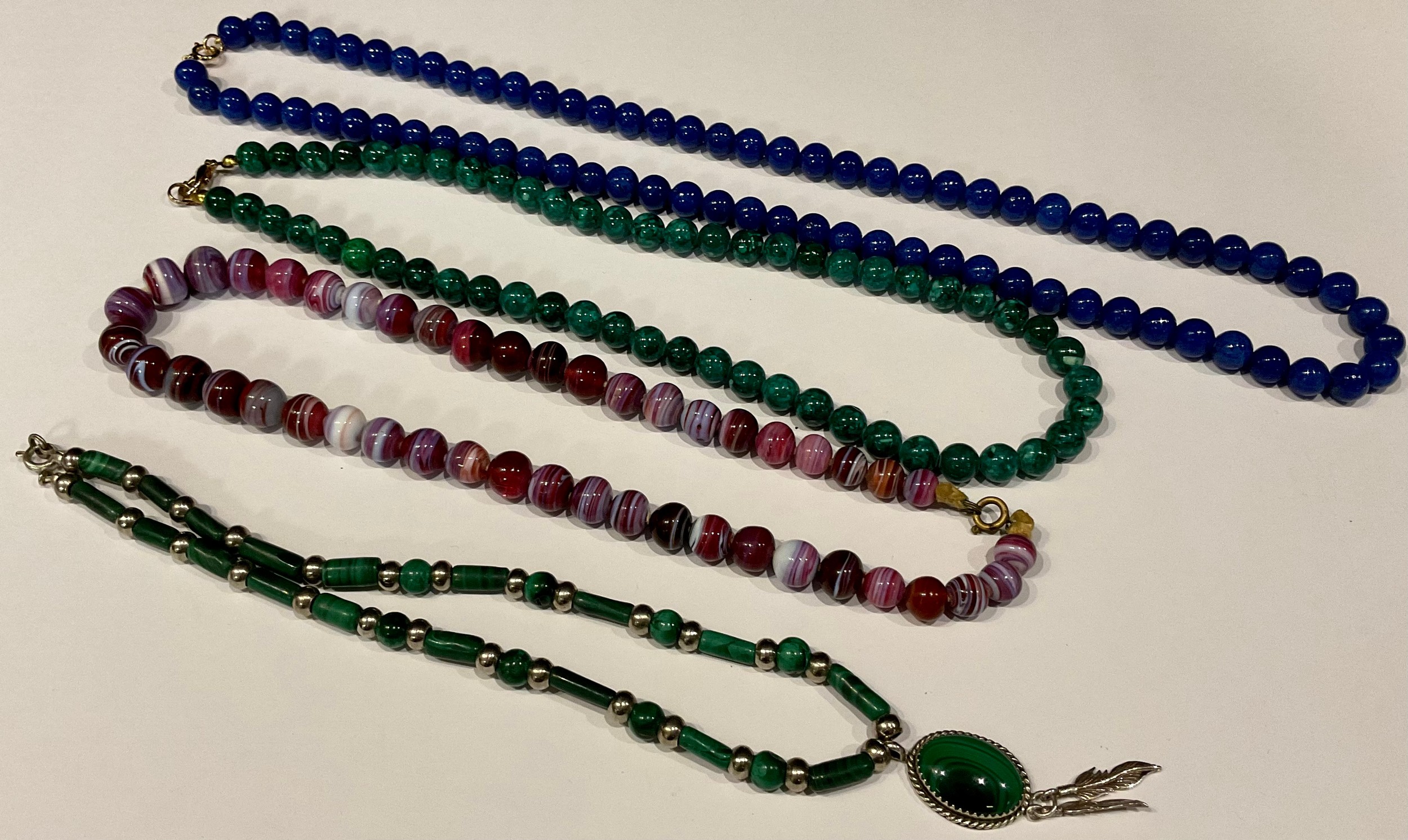 A Lapiz Lazuli bead necklace; a malachite bead necklace; another; an agate bead necklace (4)