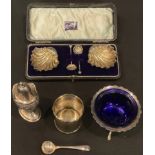 A pair of Edward VII silver scallop shell table salt cellars, with scallop shell shaped spoons