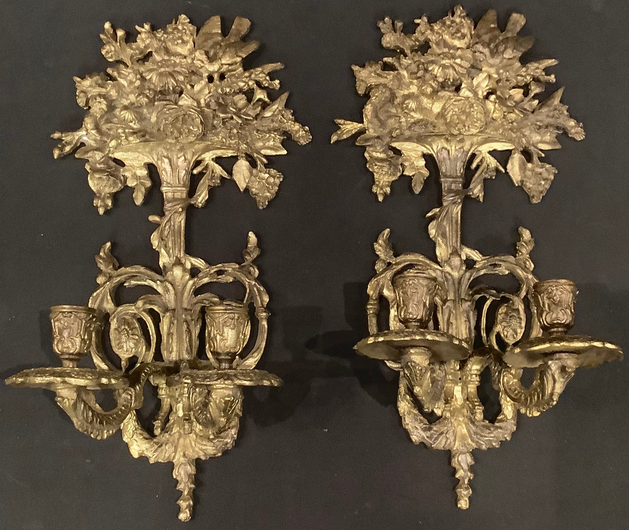 A pair of Regency style gilt metal two branch wall sconces, the crest cast with bird amongst