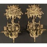 A pair of Regency style gilt metal two branch wall sconces, the crest cast with bird amongst