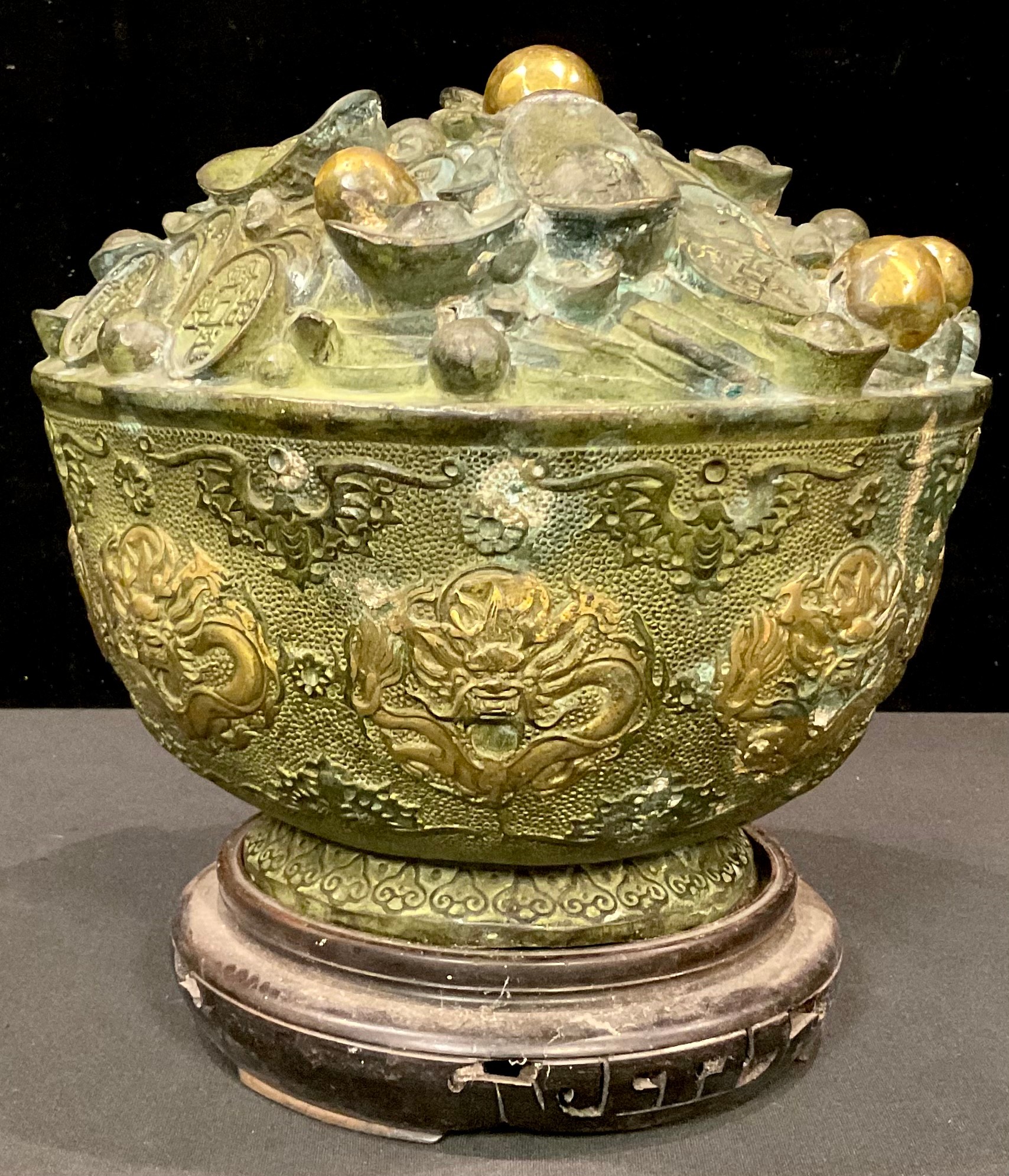 A Chinese bronzed metal fortune or treasure bowl, decorated with dragons and bats, on hardwood - Image 2 of 3
