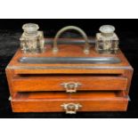 A large late Victorian oak inkstand, arched carrying handle flanked by a pair of square glass wells,