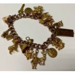 A 9ct rose gold curb link charm bracelet, marked 375, love heart clasp, various 9ct gold charms,