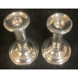 A pair of Edwardian silver candlesticks, embossed with Neo-Classical ribbon-tied swags, Henry