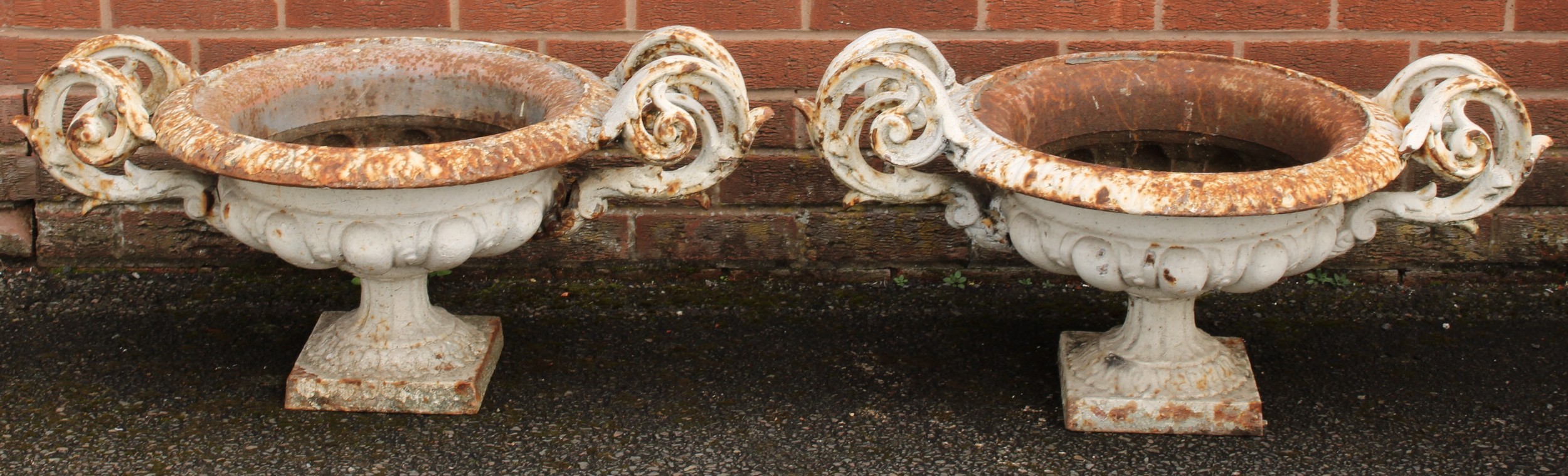 A pair of 19th century cast iron garden urns, the shoulders cast and applied with scrolling