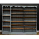 A painted pine open bookcase, 198.5cm high, 242.5cm wide, 33.5cm deep