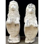 A pair of reconstituted heraldic garden lions rampant, each supporting a shield, 82cm high