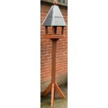 A tall covered bird table, approximately 230cm high.