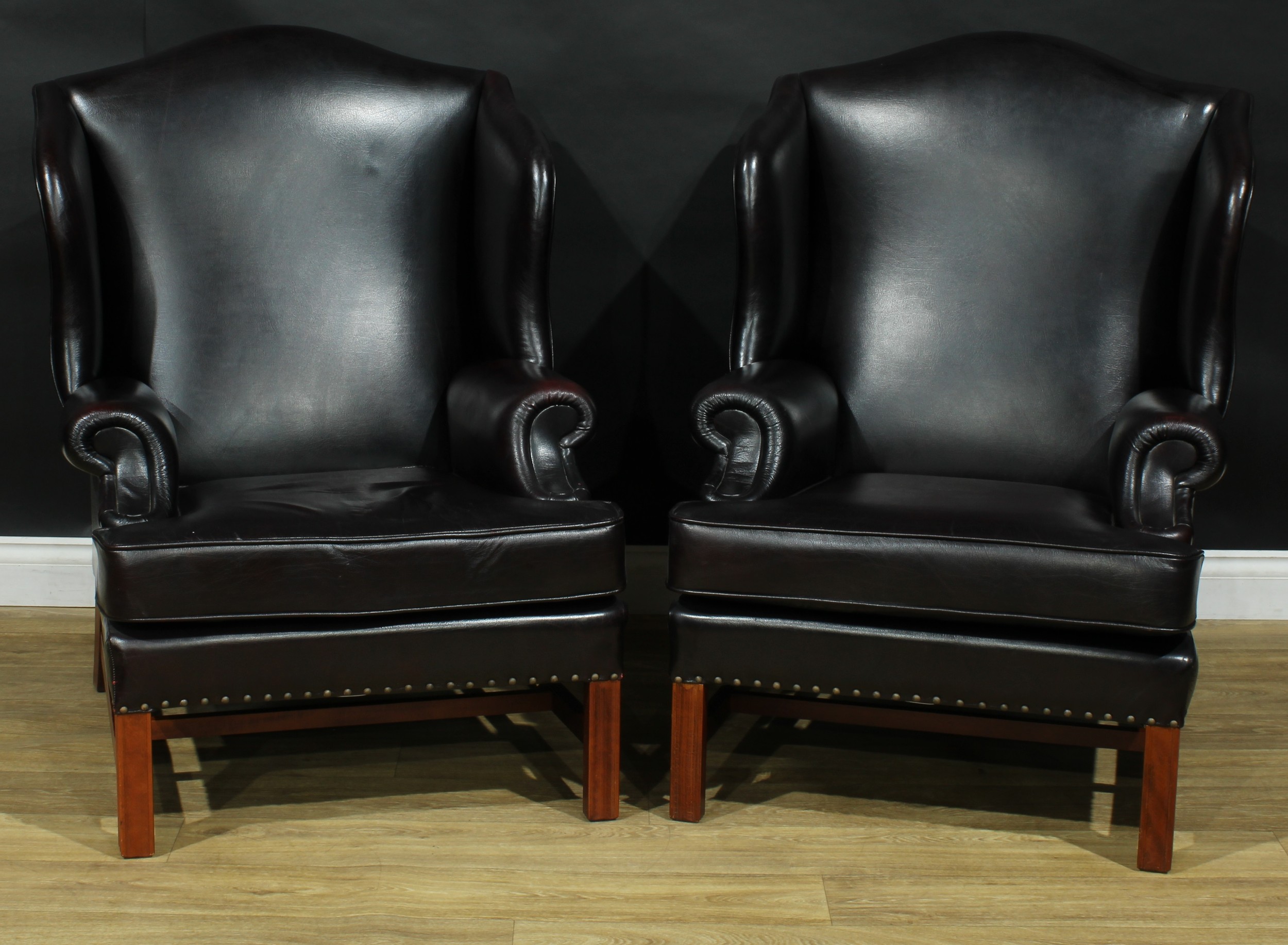 A pair of contemporary George III style wing armchairs, by Parker Knoll, stuffed-over aubergine