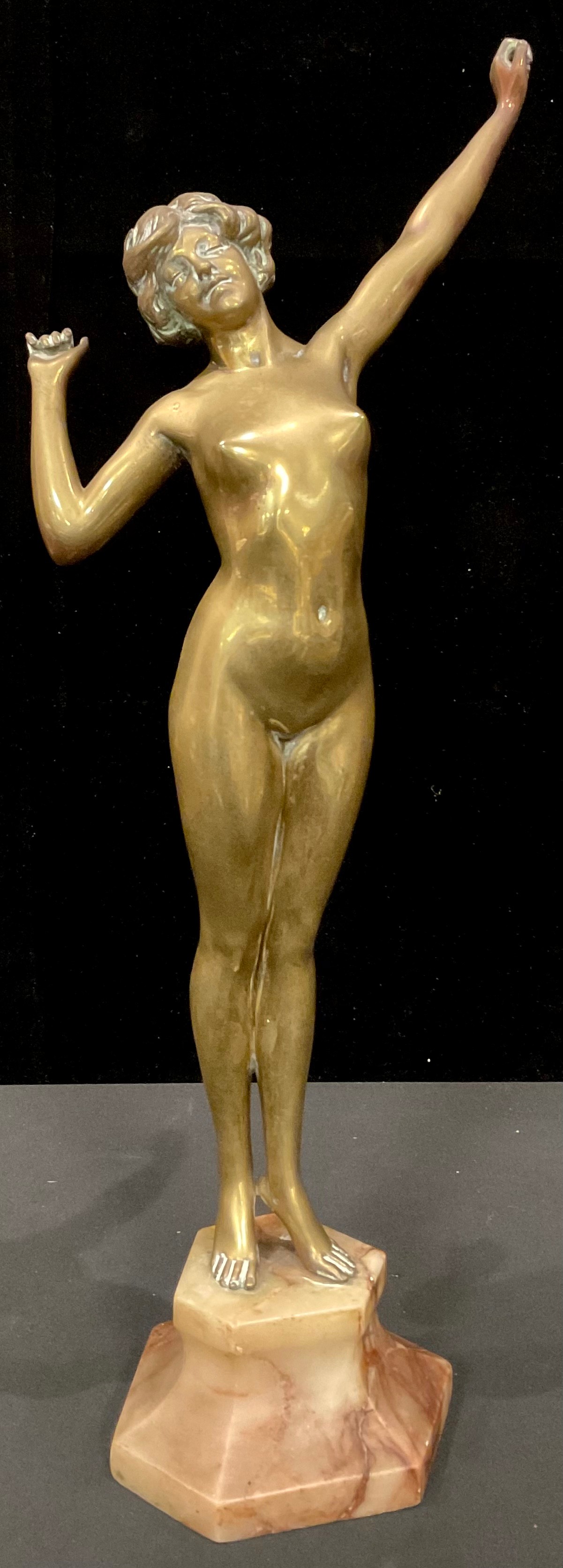 An Art Deco style brass figure, female nude on tiptoes mid stretch, angular onyx base, 55cm