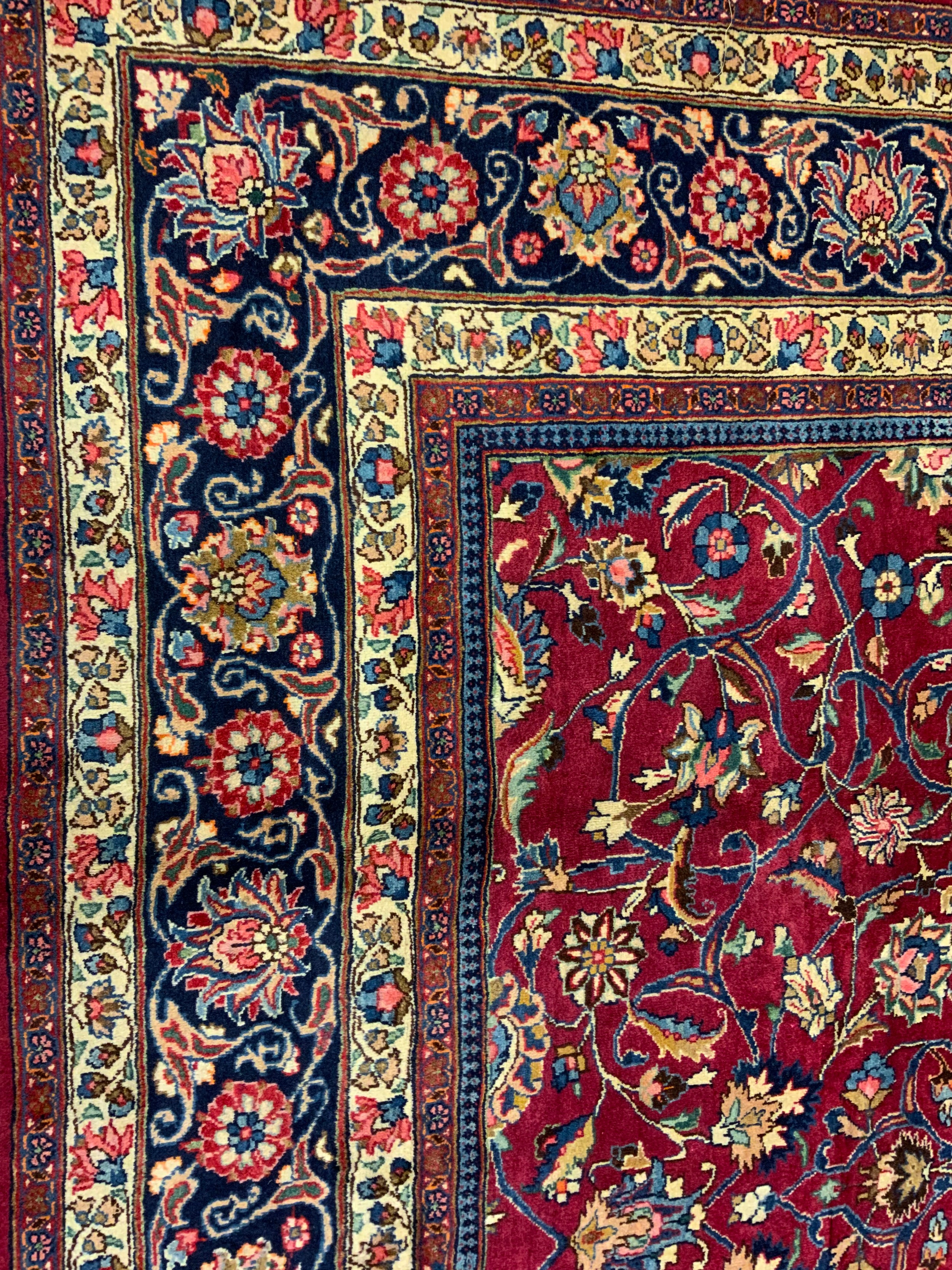 A Persian Tabriz hand-knotted rug / carpet, the field in rich red with scrolling tendrils of - Image 3 of 4