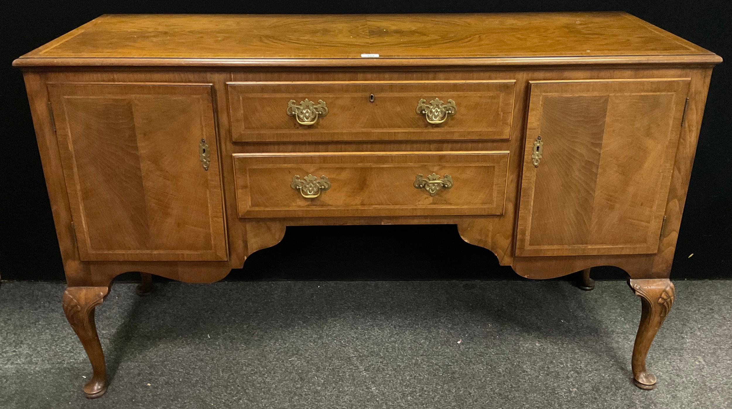 A Regency style walnut and oak crossbanded sideboard, two central graduated drawers, two cupboard