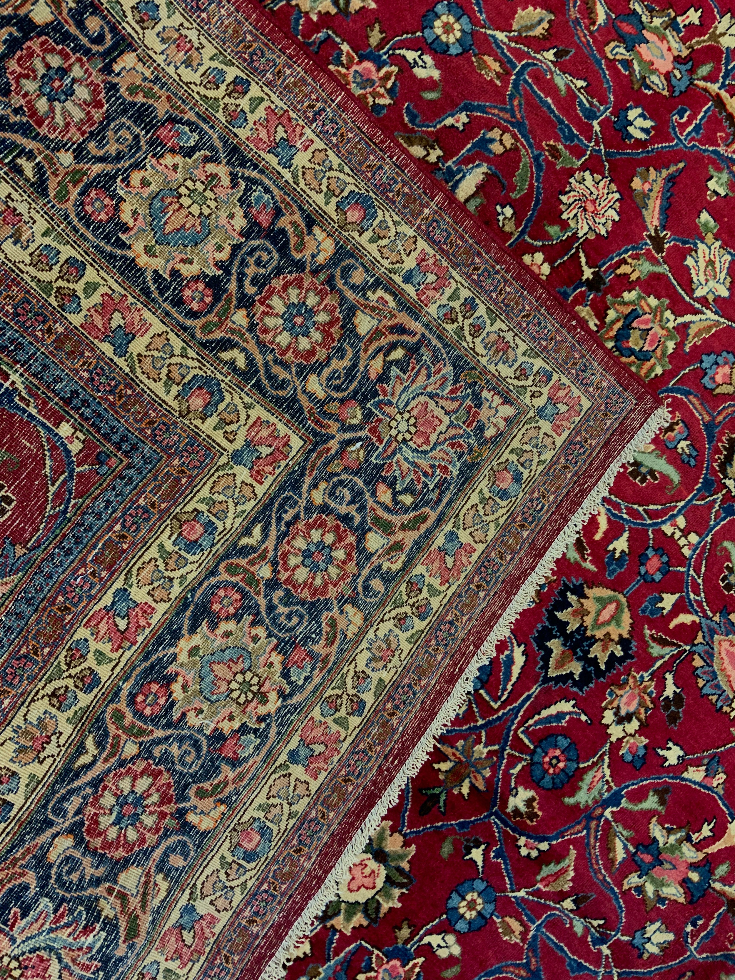 A Persian Tabriz hand-knotted rug / carpet, the field in rich red with scrolling tendrils of - Image 4 of 4