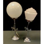 An Art Deco chrome table lamp, dancing girl, arm aloft, milk glass shade, 50cm high; another 42cm
