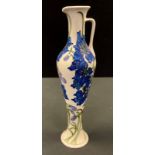 A contemporary Moorcroft jug, tube lined with blue flowers and sinuous foliage on an ivory ground,