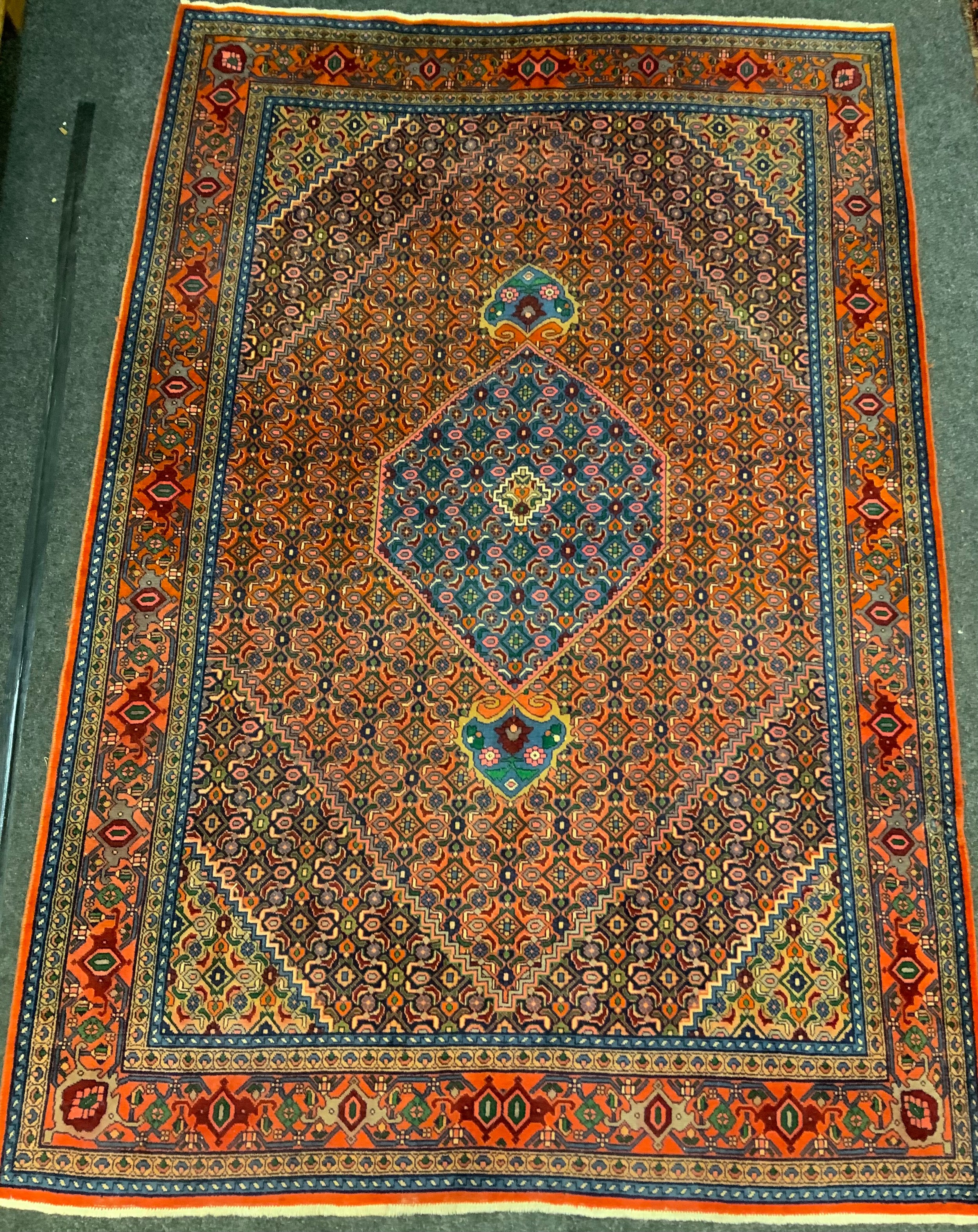 A Persian rug / carpet, hand-knotted with a central hexagonal form medallion within a field of