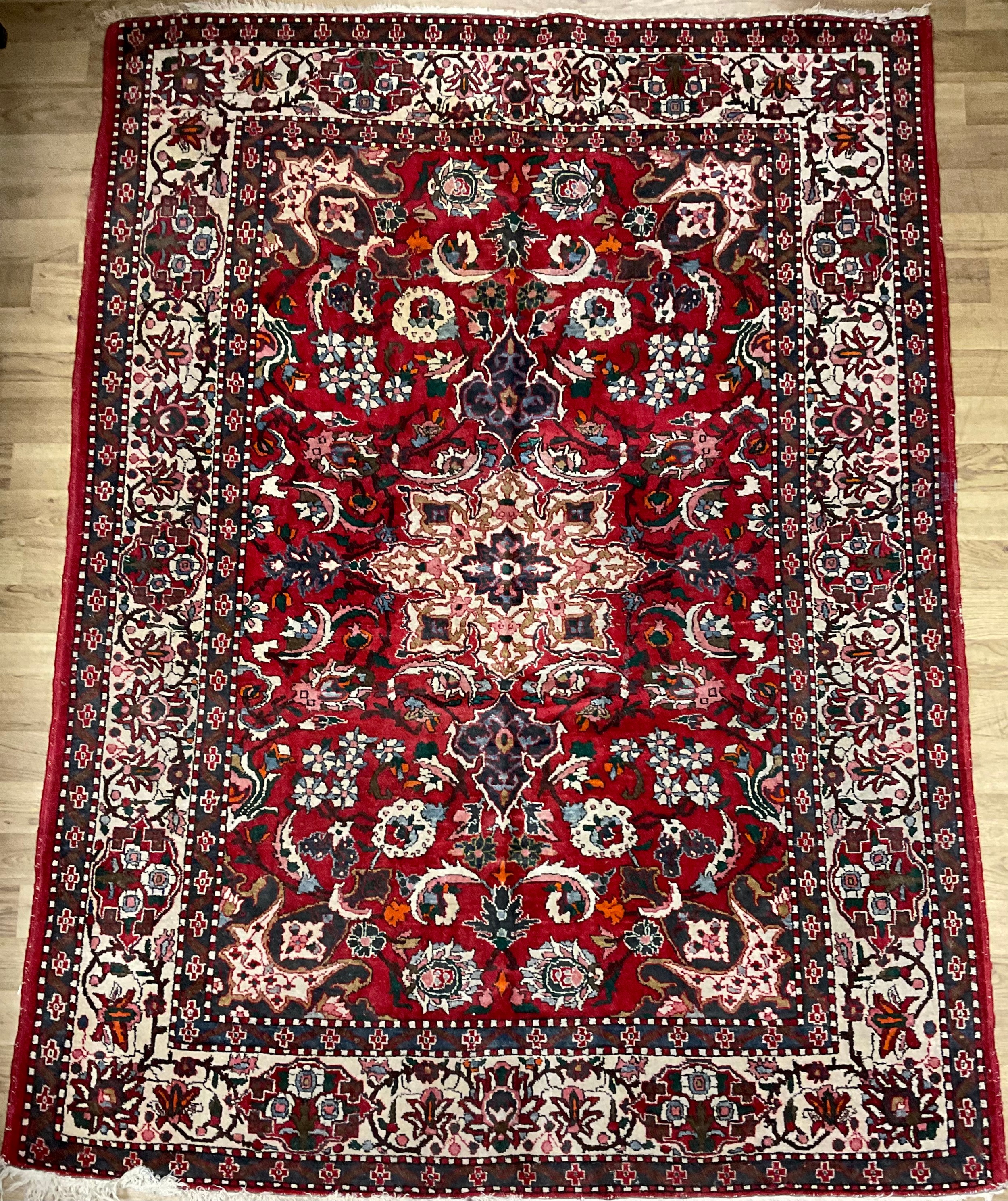 A Persian Isfahan rug, hand-knotted with central circular medallion within a field of stylised