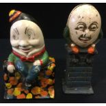 A cast iron money box, Humpty Dumpty sat on a wall, painted detailing; another (2)