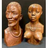 A pair of African style carved hardwood busts, a man and a woman, 44cm high, and 42cm high