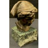 A Bronzed metal bust of boy, green and black stone base, 13cm tall