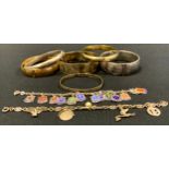 A silver hinge bangles; others, silver gilt; slide action; enamelled silver shield charms bracelet