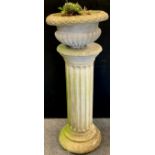 A reconstituted stone garden plinth column, fluted barrel, stepped foot, 92cm high, 42cm diameter,