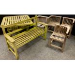 A set of four hardwood garden chairs, weathered, each measuring 65cm high x 63cm; a garden bench,