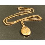 A late Victorian gold coloured metal oval photograph locket, suspended from a 9ct gold chain, 12.5 g