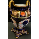 A Royal Crown Derby 1128 Imari twin handled urn, arched handles, square base, scrolled feet, first