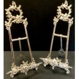 A pair of rococo style silver plated easels, 54cm (2)