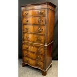 A George III style reproduction mahogany chest on chest, serpentine shaped front, seven graduated