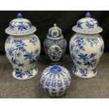 A pair of 20th century reproduction Chinese blue and white lidded jars / vases, each measuring