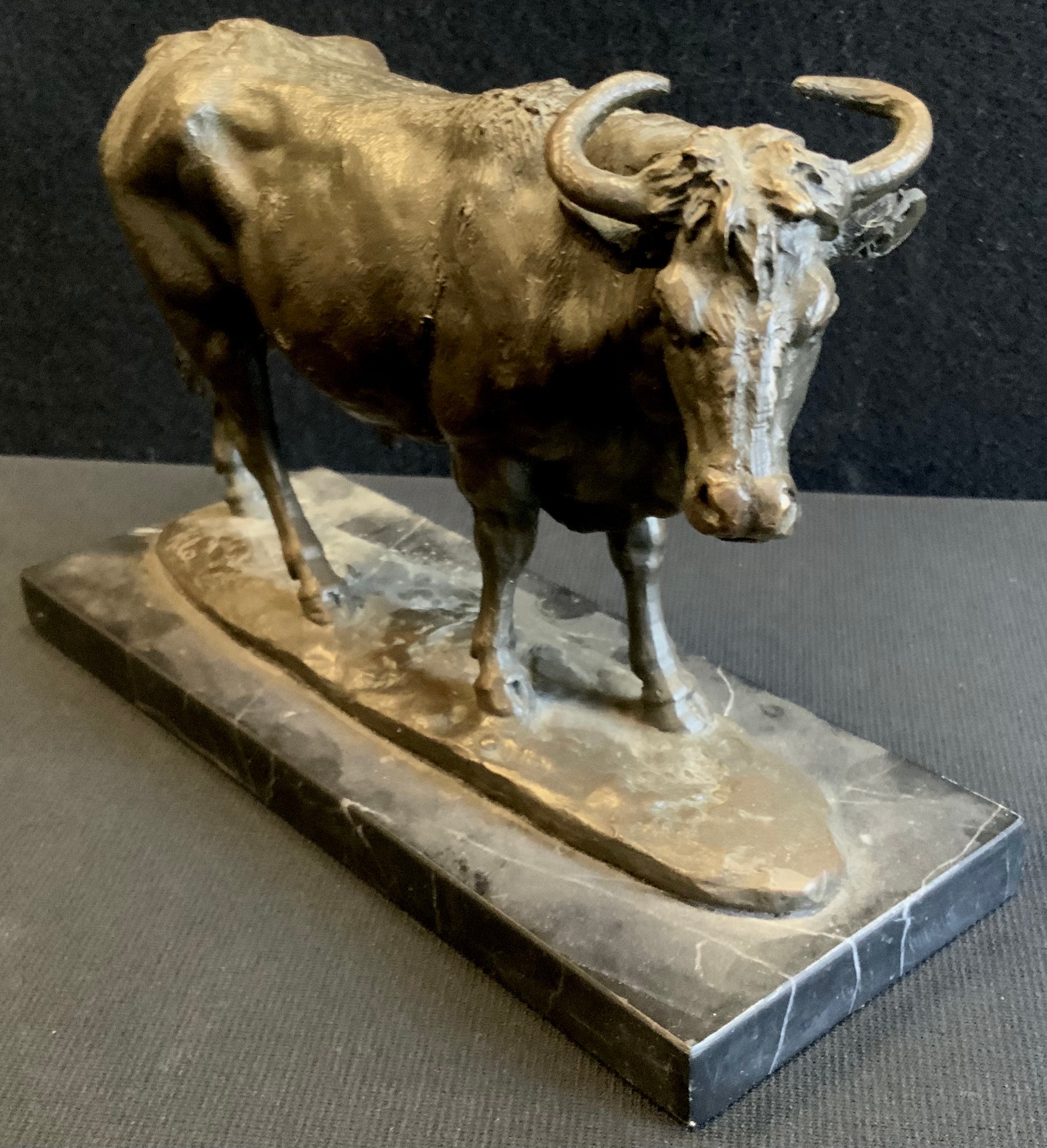 A Bronze model of a bull, signed ‘Milo’, black marble base, 20th century.