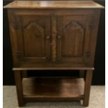 A Titchmarsh and Goodwin style oak cupboard on stand, over-sailing rounded rectangular top, pair