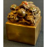 A modern gilt bronzed metal Chinese dragon seal, with green and red cabochon eyes, 10cm x 7cm