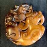 A Chinese carved hardstone embryonic dragon pendant, 5cm wide