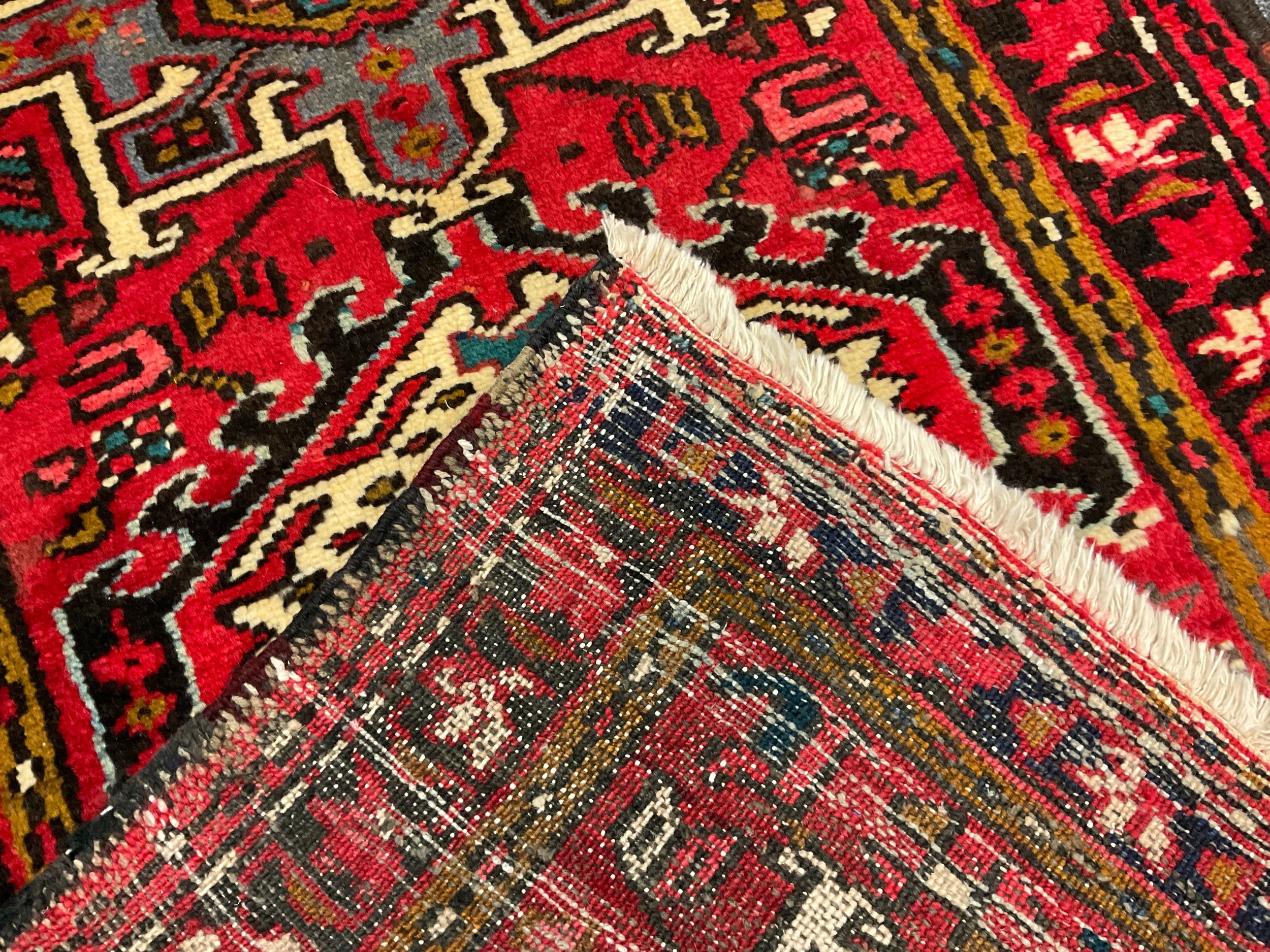 A North West Persian Heriz runner, hand-knotted in tones of red, black, blue, and cream, 275cm x - Image 2 of 2