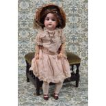 An Armand & Marseille (Germany) bisque head and fixed ball jointed composition bodied doll, the