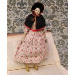 A mid 19th century painted papier-mâché shoulder head doll, the papier-mâché head with black moulded