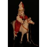 An early 20th century novelty pull-along toy, in the form of a bisque head Polchinelle or Clown