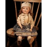 An Armand & Marseille (Germany) bisque head and ball jointed painted composition bodied doll, the