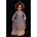 A German bisque shoulder head doll, the bisque head inset with fixed brown glass eyes, painted