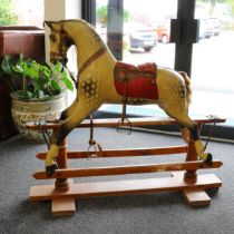 A late 19th century or early 20th century English wooden rocking Horse, the carved gesso and painted