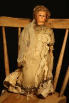 A 19th century painted papier-mâché or composition shoulder head doll, the slightly turned papier-