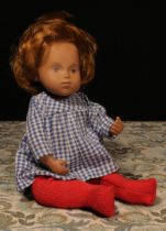A Götz Sasha Morgenthaler baby doll with auburn red hair, wearing a pink and white Gingham dress