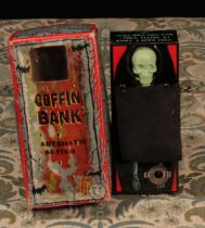 A 1960's Japanese tinplate and plastic fixed key wind novelty Coffin Bank moneybox, in the form of a