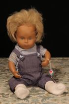 A Götz Sasha Morgenthaler baby doll with blonde hair, wearing a pair of blue 'denim' type