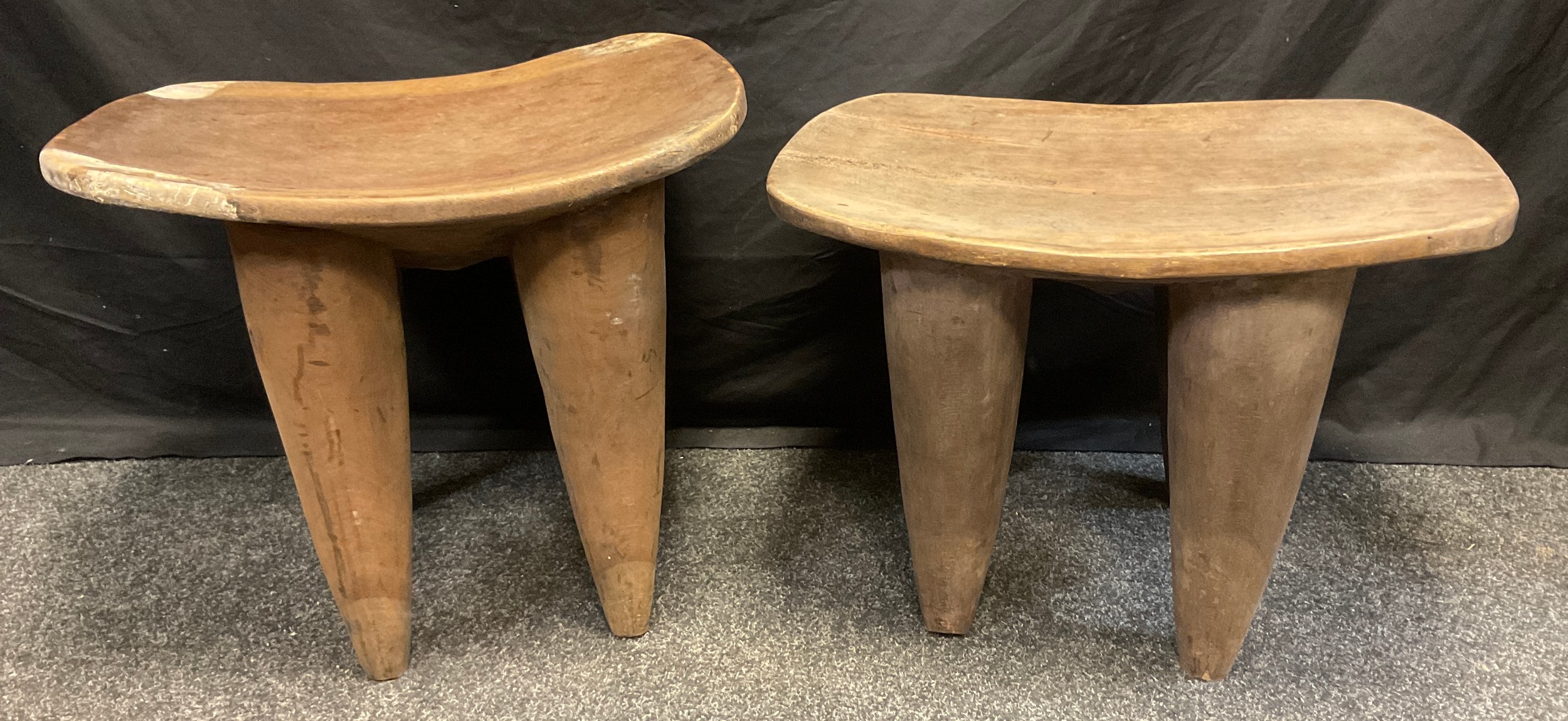 A pair of African Senufo tables made from solitary piece of hard wood, dished tops, tapering legs,