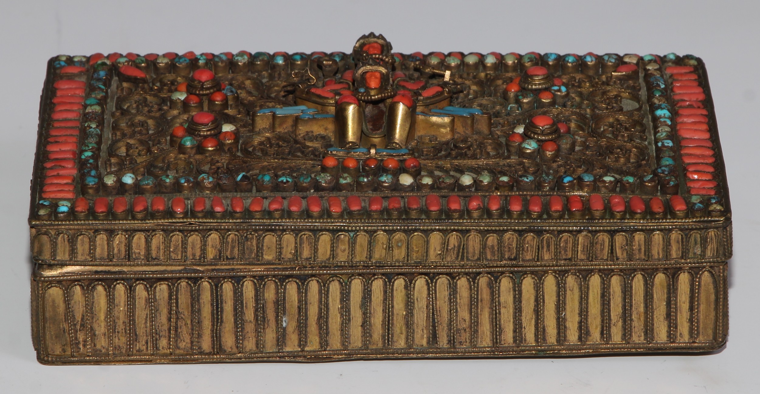 A Tibetan coral and turquoise mounted gilt brass rectangular box, hinged cover, hinged cover applied